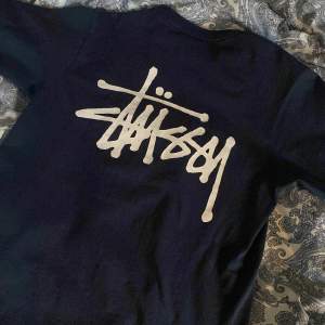 jättefin mörkblå stüssy t-shirt, bra skick, inte mycket använd. Bara pytte lite sprucken i texten på ryggen (bild 2).