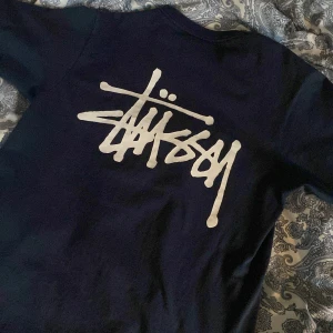 Stüssy t-shirt - jättefin mörkblå stüssy t-shirt, bra skick, inte mycket använd. Bara pytte lite sprucken i texten på ryggen (bild 2).