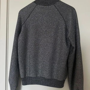 Glittrig tröja, Strl M - Jättefin glittrig tröja i storlek M från NAKD. Passar även S. Glittrig men svart i botten. Aldrig använd. Frakt tillkommer. Betalning via swish. 