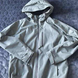 Regnjacka för dam  - Säljer en helt ny och oanvänd McKinley regnjacka i den stilrena färgen dusty green. Denna jacka är perfekt för regniga dagar, tack vare sitt vattenavvisande material och funktionella desi