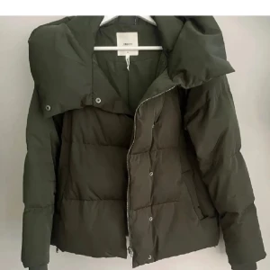 Grön object jacka  - Säljer min fina sköna gröna vinterjacka. De är i väldigt fint skick, jackan har dragkedja och knappar framtill som gör att den håller värmen extra bra. Har även en stor skön luva. Första bilden är lånad och resten mina. Jackan säljs inte längre💚