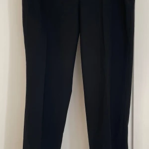 DKNY kostymbyxor i ullmix - DKNY Perry Woman’s trousers. Kostymbyxor i storlek US 4. Stängs med blixtlås på sidan. Två bakfickor. I mycket gott skick. Det finns en matchande kavaj till. Se separat annons.