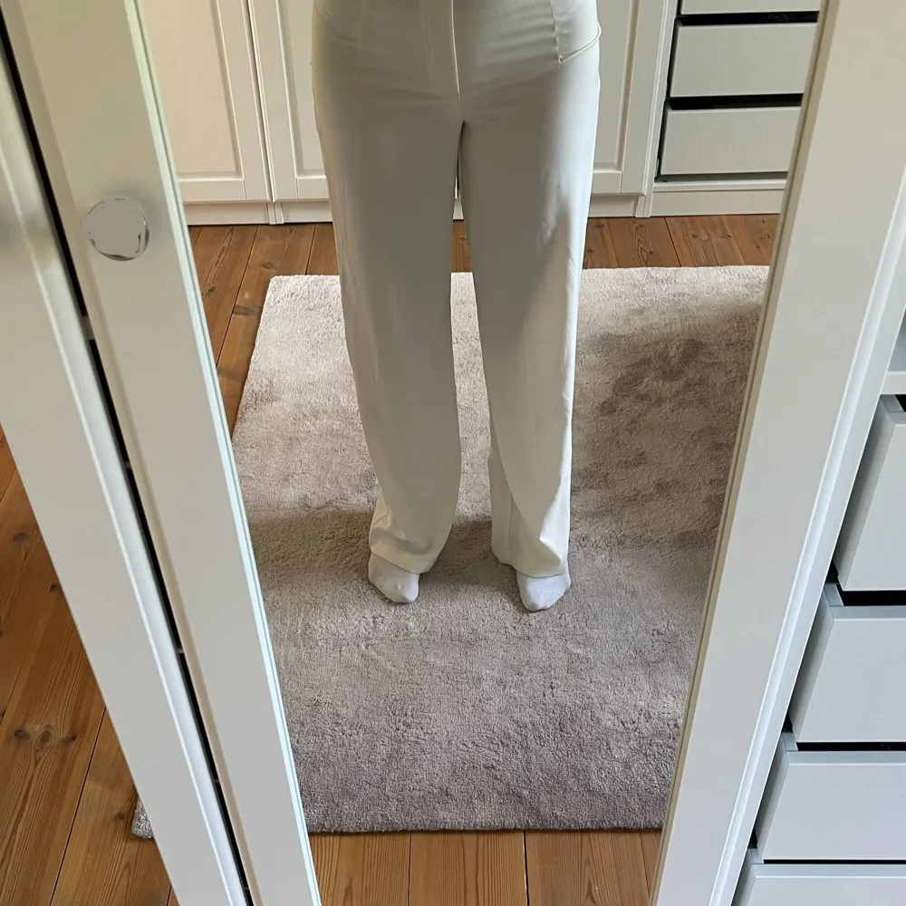Säljer ett par snygga vita byxor i loose fit. De är högmidjade och har en stilren design som passar perfekt till både vardag och fest. Byxorna är gjorda i ett bekvämt material som känns skönt mot huden. Knäppning i sidan.. Farkut & Housut.