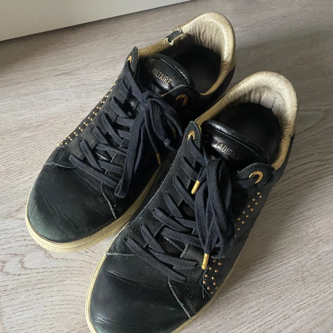 Svarta sneakers med gulddetaljer