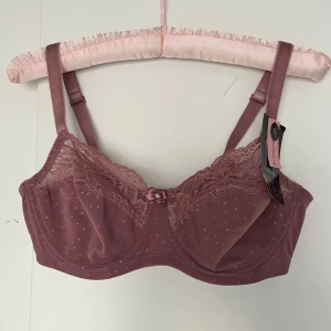 Ny Hunkemöller BH - Superfin BH får Hunkemöller med spets och rosett. Aldrig använd, prislappen kvar! 75D, Orginalpris 389kr
