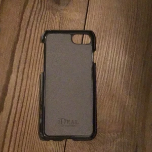 Mobilskal från iDeal of Sweden - Säljer ett snyggt mobilskal från iDeal of Sweden med ett coolt marmormönster i bruna och vita nyanser. Skalet är i bra skick och passar perfekt för att ge din mobil en stilen look. Perfekt för dig som vill ha både stil och skydd! 💼