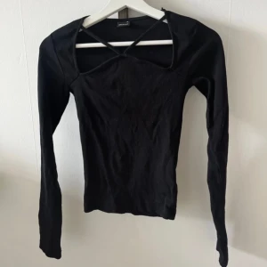 Svart topp - Svart långärmad topp med detalj 