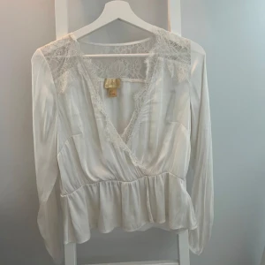 Vit topp - Vit topp i satin liknande material med spets från H&M i storlek M. 