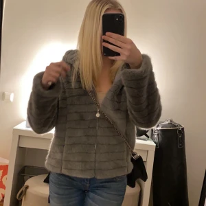 Grå pälsjacka från Flash Woman - säljer min grå pälsjacka som tyvärr aldrig kom till användning. jackan är perfekt nu till hösten/vintern.  den är storlek S men skulle också funka som XS. 