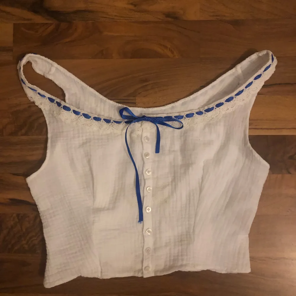 Gullig Croppad topp med spetsdetaljer!đ· BlĂ„ttband som knyts framtillâŁïž Perfekt till sommaren dĂ„ den Ă€r sydd i ett bomullstygâïž. YlĂ€osat.