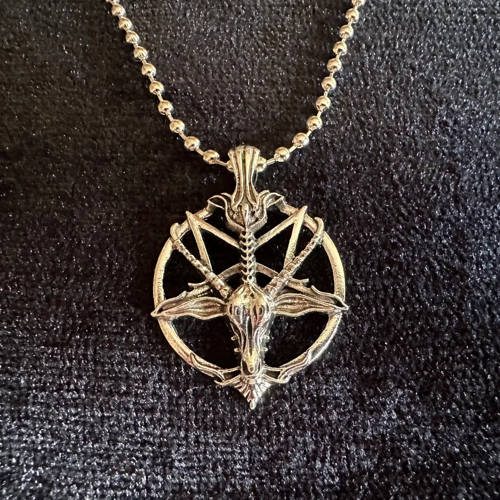 Silverfärgat halsband med pentagram i form av Baphomet, ibland kallad getguden eller bockguden från Mendez.   Amuletten är cirka 3,5 cm lång och 2,5 cm bred.   Kulkedjehalsbandet är ca 48 cm långt.  Nytt och i perfekt skick.   Jag prutar inte. . Accessoarer.