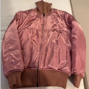 Rosa bomberjacka i satin - Säljer en japansk rosa bomberjacka i satinmaterial. Den har en dragkedja framtill & ribbade muddar vid ärmslut och nederkant. Perfekt för höst och vår när du vill ha något stilrent och bekvämt. Jackan är i bra skick och redo för nya äventyr! 🌸