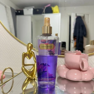 Love Spell kroppsspray - Säljer en flaska av Victoria's Secret Love Spell kroppsspray. Den har en härlig lila färg och kommer i en genomskinlig plastflaska med en guldig spraypump. Flaskan rymmer 250 ml och doften är en fräsch och blommig mix som är perfekt för dagligt bruk. Perfekt för att känna sig fräsch och dofta gott hela dagen!