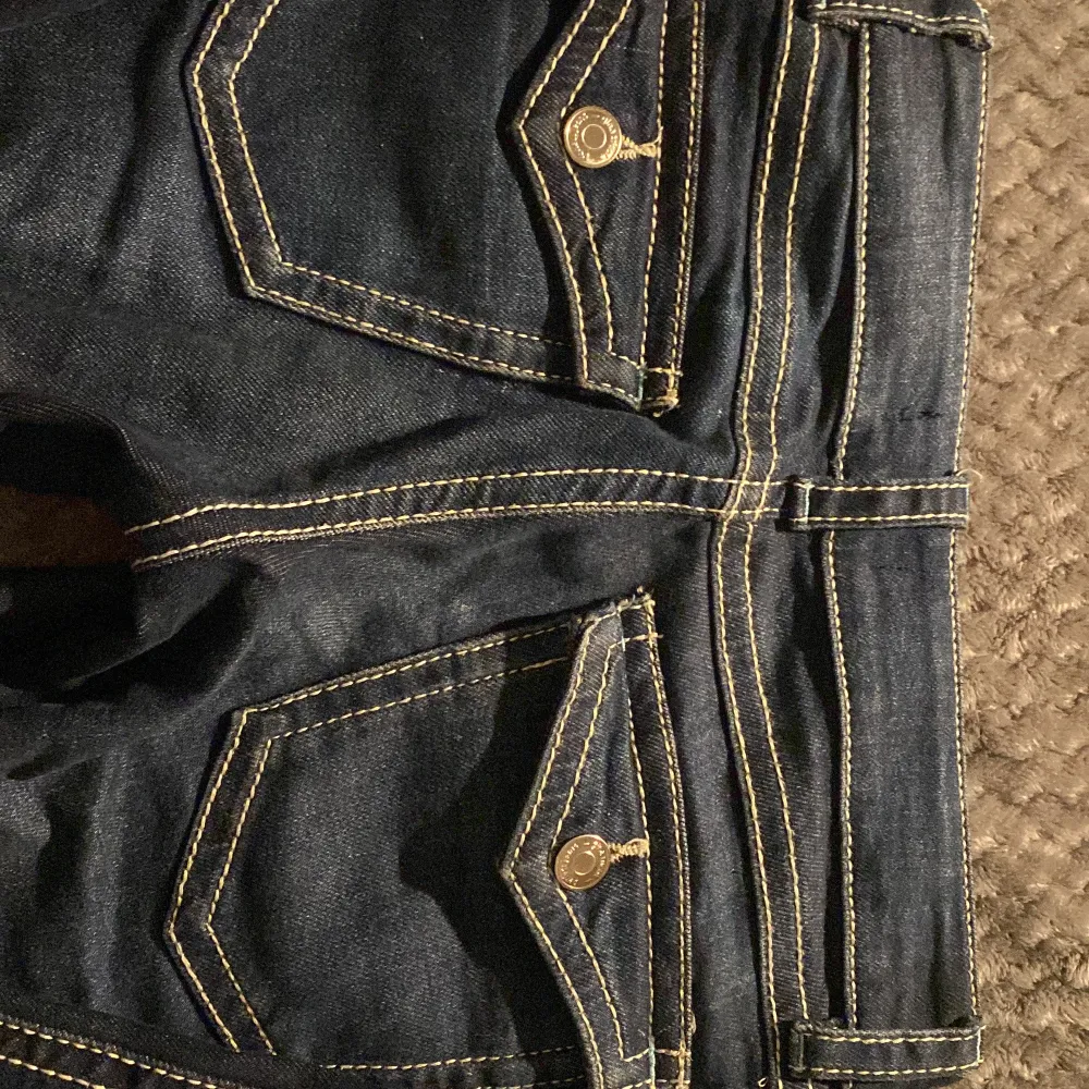 snygga mörkblå jeans med kontrastsömmar och fina knappar på fickorna. ser som sagt ut skrynkligare och fulare på bilderna än i verkligheten som de andra gråa jeansen på min profil men är troligen väldigt fina och bra! använt runt 5-7 ggr men har inga fettfläckar eller fläckar alls, jeansen har spruckit lite längst ner på ett av benen men det går att sy eller bara inte bry sig om😅så det kommer inte skada jeansen mer. perfekt för en med size 152!. Farkut & Housut.