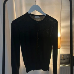 Mörkgrå kofta från Moncler - Pris kan diskuteras. Snygg mörkgrå kofta från Moncler med knappar framtill. Perfekt för lager-på-lager och passar till många olika outfits. Klassisk design med rund hals och långa ärmar.