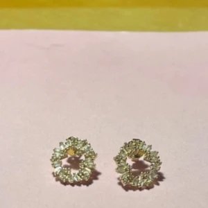 Glittriga örhängen i cirkelform från makeup Mekka  - Snygga glittriga örhängen i cirkelform med en elegant design. Perfekta för att ge en touch av glamour till din outfit. De har en fin glans och är lätta att bära. Aldrig använda. Köpte från makeup Mekka. Säljer för 110 kronor.