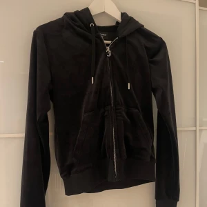 Svart Juicy Couture hoodie - Säljer en svart hoodie från Juicy Couture i mjukt material. Den har dragkedja framtill och en praktisk huva med snörning. Säljer då den inte kommer till användning längre☺️🖤