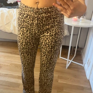 Leopardmönstrade byxor från Gina - Snygga leopardmönstrade byxor med normal midja och tight passform. Perfekta för att göra ett statement med din outfit. Tappat bort snöret. Byxorna är från Gina Tricot. 