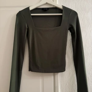 Grön långärmad topp från Amisu - Snygg grön långärmad topp från Amisu med en fyrkantig halsringning. Perfekt för en stilren look. Tillverkad i ett mjukt och bekvämt material.