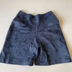 Alphalete surface power short  - Alphalete surface power short i blue pebble print. Knappt använda, mycket fint skick! Har alldeles för mycket träningskläder därav säljer jag! Köpta för 550 kr 