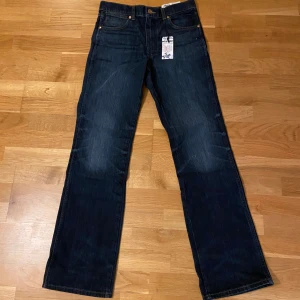 Mörkblå jeans från Wrangler - Snygga mörkblå jeans från Wrangler med klassisk design. De har en rak passform och är tillverkade i slitstarkt denim. Perfekta för en avslappnad stil. (Helt nya)