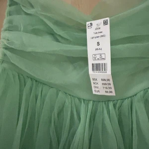 Ljusgrön tyllklänning - Säljer en drömmig ljusgrön tyllklänning med flera lager som ger en härlig volym. Perfekt för en somrig look med sin luftiga design. Klänningen har en romantisk känsla och passar perfekt för speciella tillfällen. Bara fråga om fler bilder för den helt oanvända klänningen!