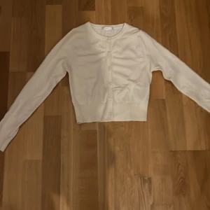 Beige kofta från Gina Tricot - Säljer en stilren beige kofta från Gina Tricot. Koftan har långa ärmar och knappar framtill, perfekt för lager-på-lager-stil. Passar bra till både vardag och lite finare tillfällen. 🧥✨