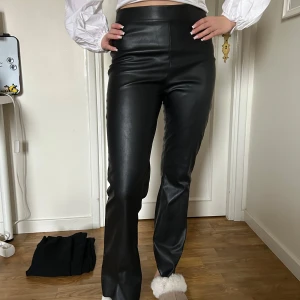 Svarta skinnbyxor - Snygga svarta skinnbyxor med hög midja och bootcut-stil. Perfekta för en trendig look. Nästan aldrig använda gjorde en stor rensning i garderoben. Storleken är i S men känns lite mindre. 