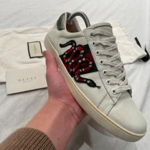 Gucci Ace - Sjukt snygga Gucci Ace av Snake modellen. Skick 7/10. Strlk 44 (Uk 10). Dustbag och autentiska papper ingår. Finns en liten defekt, bild kan fås i dm.