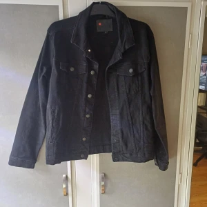 Svart jeansjacka från Denim Project - Snygg svart jeansjacka från Denim Project i storlek L. Jackan har knappar framtill och två bröstfickor. Den är väldigt bekväm är skön att ha på sig.      Priset är inte fast