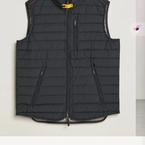 Svart pjs väst - Snygg svart dunväst med dragkedja och praktiska fickor. Perfekt för lager-på-lager under kyliga dagar. Den har en diskret design med en gul detalj vid halsen som ger en cool kontrast. Äkta! Kvitto och tag medföljer. Kontakta för bilder. 