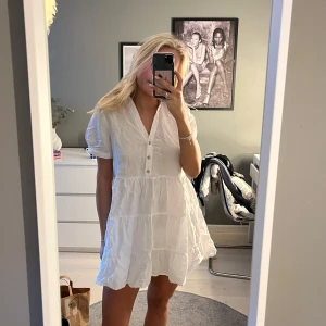 Vit kortklänning med knappar - Säljer denna söta linneklänning från Zara! Endast använd en gång!💞