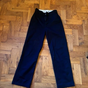 Svarta byxor från Dickies - Snygga svarta byxor från Dickies med en klassisk design. Byxorna har en rak passform och är tillverkade i ett slitstarkt material. Perfekta för en stilren look.