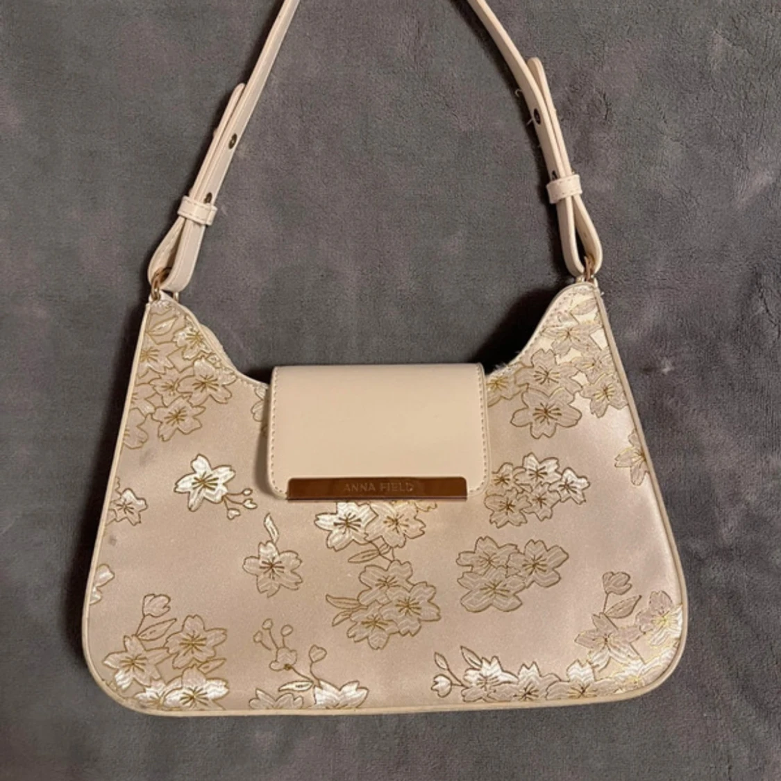 Beige axelväska med blommigt mönster