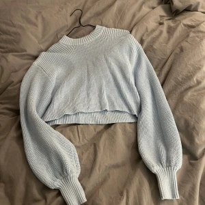 Ljusblå stickad tröja från Monki - Säljer en ljusblå stickad tröja från Monki. Tröjan är croppad med långa ärmar och har en ribbad struktur. Perfekt för en stilren och bekväm look. 💙Nästan aldrig använd. Köparen står för frakten 