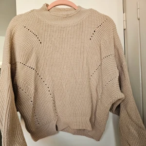 Camel Pointelle Croped Stickad Jumper - Kort tröja / jumper av Miss Selfridge Akryl 100% Oversized!  Tröjan har rund halsringning och nedhasad axelsöm. Lång ballongärm med snävt, ribbstickat ärmslut. Ribbstickad i nederkant!