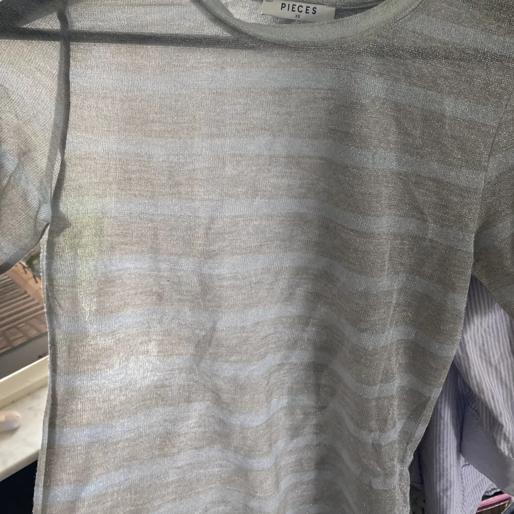 T-shirt i glittrig mesh med ljusblåa och silvriga ränder.  Stretchig i materialet, passar på s/xs men även på M om man vill ha en tight fit. Bra skick. T-shirts.