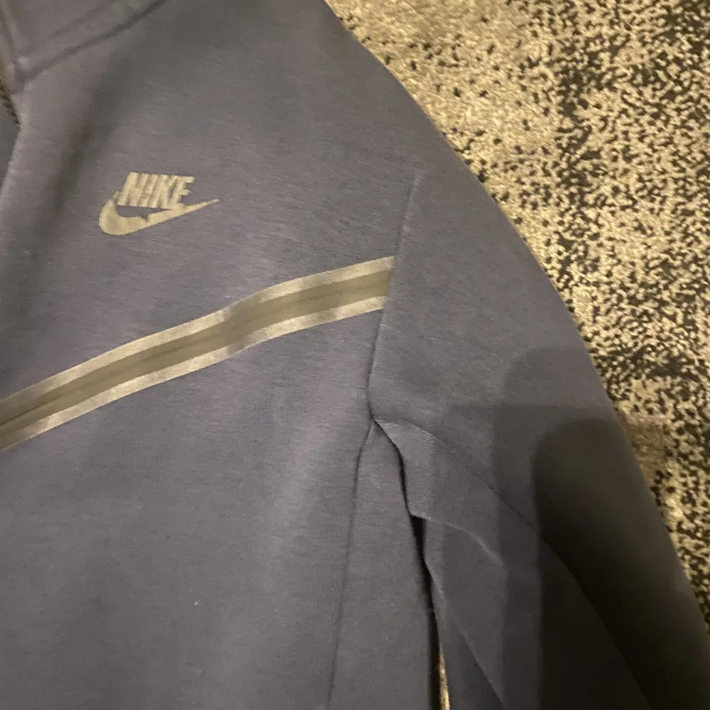 Säljer nu min mörk blåa Nike tech tröja den är lite blekare eftersom den har gott i tvättmaskinen ett par gånger men den är i bra skick ändå. Hoodies.