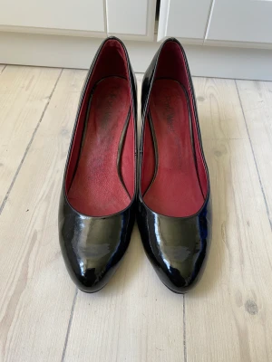 Klackskor lack - Svarta klackskor i lack med röd interiör. Strl 39 men lite smala i tån