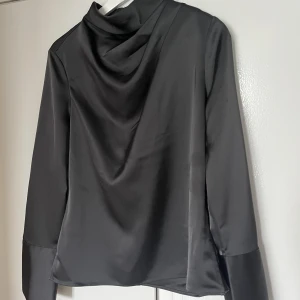 Blus - Jättevacker draperad blus i så gott som nytt skick. Använd 1 gång. Gör sig väldigt fin i bättre ljus (se bild 2). 