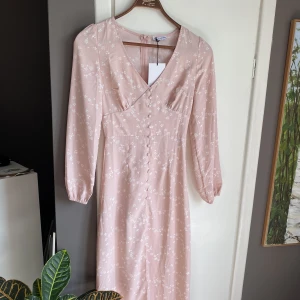 Adore likande klänning - - långklänning  - Rosa med blommor - knappar 