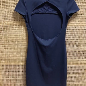  Blå miniklänning med öppen rygg grå nelly - Vad: Blå klänning med öppen rygg  Märke: Nelly Trend Storlek: S (mer som XS) Material: 70% polyester 25% viskos och 5% elastan Skick: Hittar inget att anmärka på 