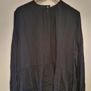 Blus med volang - Svart blus med volang nertill. Knappt använd.