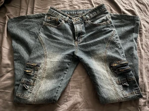 cargo liknande jeans - assnygga jeans ifrån l.s.x.q! står storlek 36 men psssar XXS/XS. väldigt unika och väl omhändertagna, små defekter som att knappen är lite lös samt lite slita längs ner. mått- midja 32cm tvärsöver (65cm runtom), innerben 74cm. finns ett bälte till!💕