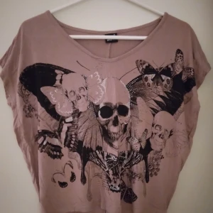 Gammelrosa vid top, Gina Tricot. Strlk: Small. Döskalle. Viskos. - Gammelrosa vid top, från Gina Tricot. Strlk: Small. Döskalletryck med fjärilar, blommor etc. Material: Mjuk viskos. Fint skick. Felfri.