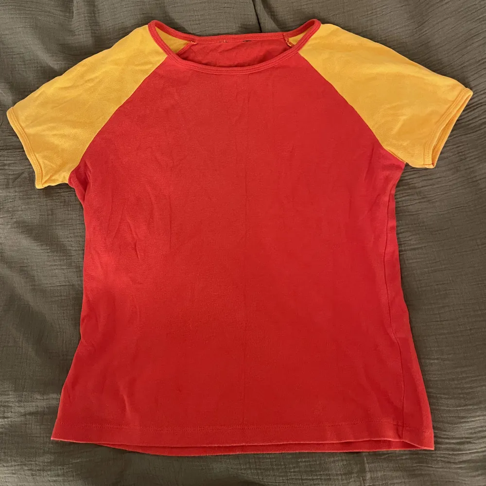 En mycket snygg T-shirt med orangea armar och rött bröst👌🏼. T-shirts.