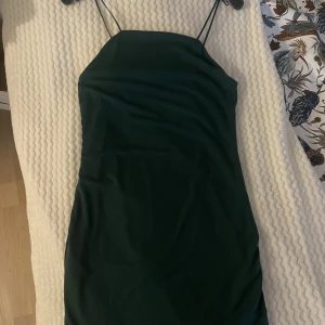 Mörkgrön klänning  - Smickrande mörkgrön klänning som tyvärr inte kommer till användning då jag sällan använder klänning.  Jättefin med tunna band, normal i storleken 