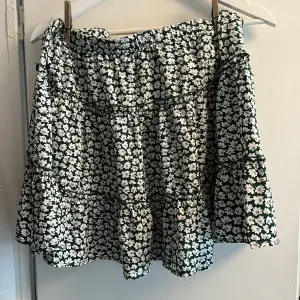 Somrig kjol från SHEIN med grönvita blommor. Nästan aldrig använd, skick 10/10. Storlek L