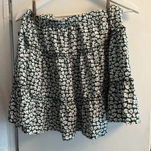 Somrig kjol - Somrig kjol från SHEIN med grönvita blommor. Nästan aldrig använd, skick 10/10. Storlek L