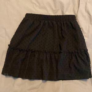 En svart fin volang-kjol från SHEIN i storlek S. Kvalitén är som vilken annan kjol som helst. Säljer den eftersom den inte kommit till användning:)